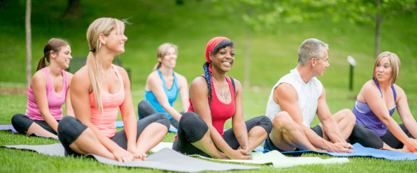 a group people practicing yoga outdoor